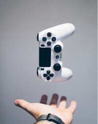 gaming concole on gray background in the air with a hand waiting to catch it